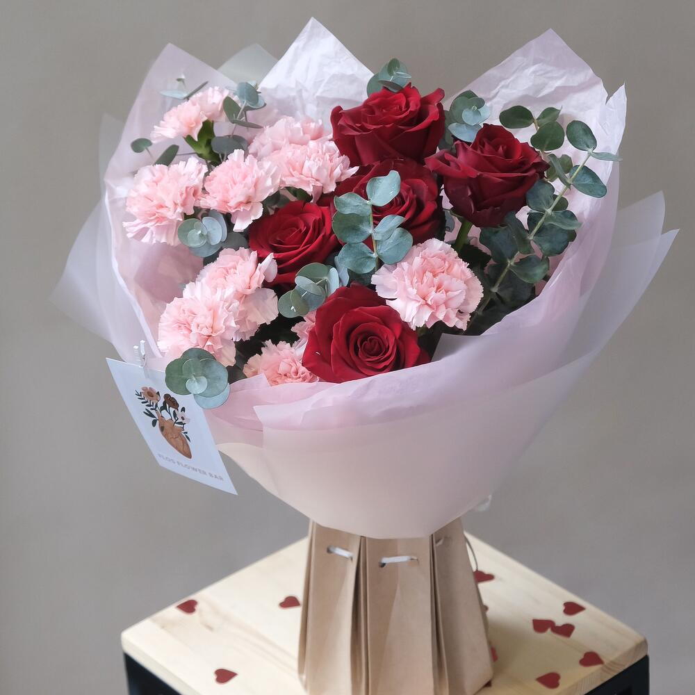 Bouquet of red Explorer roses and pink dianthus with a romantic mood